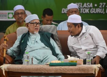 AHMAD Fadhli Shaari (kanan) memperkatakan sesuatu kepada Abdul Hadi Awang pada Pelancaran Jentera Pilihan Raya Pemuda Pas Negeri Terengganu di Rusila, Marang, malam tadi. - UTUSAN/PUQTRA HAIRRY ROSLI 