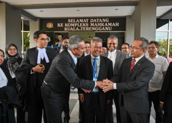 Mohd. Zubir Embong (kanan) bersalam dengan peguamnya, Mohd Hafarizam Harun sambil disaksikan Pengerusi Badan Perhubungan UMNO Negeri Terengganu, Datuk Seri Ahmad Said (tengah) selepas berjaya dalam petisyen mencabar keputusan PRU15 bagi Parlimen Kuala Terengganu semalam. - UTUSAN/PUQTRA HAIRRY ROSLI