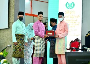 MOHD Shukri Ramli (kanan) menyampaikan anugerah kepada salah seorang penerima sewaktu Majlis Maal Hijrah Peringkat Negeri Perlis di Sekolah Menengah Sains Tuanku Syed Putra, Kangar, Perlis hari ini.- UTUSAN