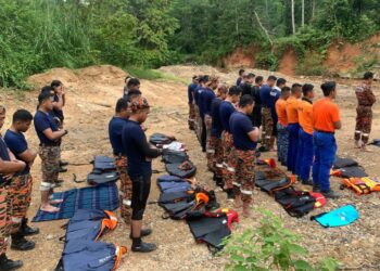 KIRA-KIRA 30 anggota pasukan penyelamat  menunaikan solat hajat bagi memudahkan pencarian mangsa terakhir tragedi kepala air  di Jeram Mawar, Air Putih, Kemaman, hari ini. - UTUSAN/NIK NUR IZZATUL HAZWANI NIK ADNAN