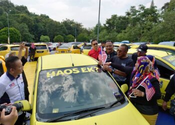 PANDAK AHMAD memasang Jalur Gemilang pada kenderaan yang melakukan formasi berbentuk Jalur Gemilang terbesar di Sireh Park, Iskandar Puteri.