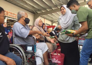 FUZIAH Salleh menyampaikan sumbangan Bakul Rahmah kepada golongan memerlukan pada majlis pelancaran inisiatif Payung Rahmah di Pasar Raya Fresh Choice di Taman Tas, Kuantan, Pahang. - UTUSAN/ DIANA SURYA ABD WAHAB