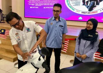 AHMAD Nazri  Abd. Kader (kiri) menampal pelekat keselamatan kenderaan pada  motosikal pada Program Pengurusan Keselamatan Jalan Raya) Tahun 2023 di Kota Bharu, Kelantan  hari ini.- UTUSAN/ ROSLJZA MOHAMED