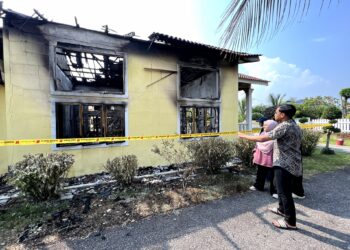 MUHAMMAD Faaiz Azhar Mohd. Yusof bersama kakitangan lain menunjukkan asrama Madrasah Taufiqiah, Kampung Bagan Pinang, Port Dickson yang musnah dalam kebakaran pagi tadi.-UTUSAN/ZAKKINA WATI AHMAD TARMIZI.