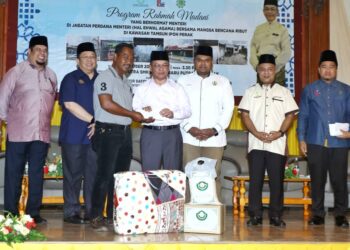 MOHD. Na'im Mokhtar (tengah) menyampaikan sumbangan kepada mangsa ribut pada majlis di SMK Bandar Baru Putra di Ipoh hari ini. - UTUSAN/MUHAMAD NAZREEN SYAH MUSTHAFA