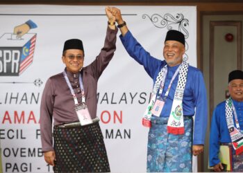 RAJA Mohamed Affandi Raja Mohamed Noor dan Ahmad Samsuri mengangkat tangan selepas diisytiharkan sebagai calon PRK Parlimen Kemaman di Chukai, Kemaman, hari ini. - UTUSAN/PUQTRA HAIRRY ROSLI