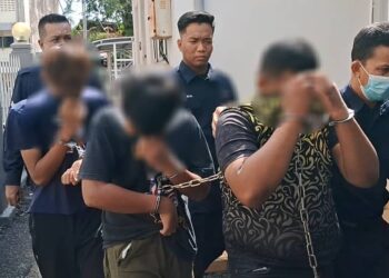 SUSPEK (tengah) yang disyaki meliwat kanak-kanak berusia enam tahun dibawa keluar dari Mahkamah Majistret Kemaman, hari ini. - UTUSAN/NIK NUR IZZATUL HAZWANI NIK ADNAN