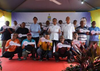 MOHAMAD Abdul Hamid (tengah) dan Farizan Darus (tiga dari kanan) bersama nelayan dalam majlis penyerahan bantuan bot dan enjin di unit nelayan Permatang Tepi Laut,  Pulau Pinang, semalam.