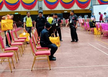 KAKITANGAN SPR membawa kertas undi di pusat penjumlahan rasmi di Chukai, Kemaman, malam ini.
