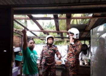 ANGGOTA bomba membuat pemantauan dan melihat kerosakan dialami kediaman dilanda ribut di Kampung Pulau Jawa di Pekan, Pahang. - FOTO IHSAN JBPM PAHANG