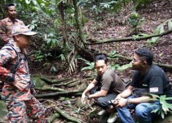 ANGGOTA bomba bertanyakan sesuatu kepada dua lelaki yang ditemukan selamat selepas tersesat ketika mendaki Bukit Janda Mandi, Kijal, Kemaman, semalam.