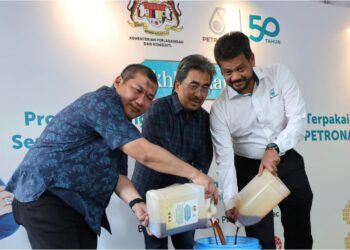 JOHARI Abdul Ghani,  Timbalan Ketua Setiausaha (Komoditi), Datuk Razali Mohamad dan Pengarah Urusan Petronas Dagangan Berhad, Azrul Osman Rani (kanan) melakukan gimik mengumpul minyak masak terpakai ke dalam tong kutipan sempena pelancaran Program Pengumpulan Minyak Masak Terpakai dan Ikhlas Ramadan bersama Gas Petronas di Bazar Ramadan Desa Pandan, Kuala Lumpur, hari ini. - UTUSAN/AMIR KHALID