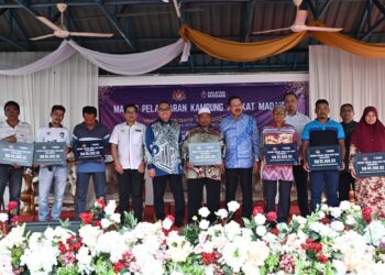 ZUKI Ali (depan, empat kanan) bergambar bersama penerima bantuan Rumah Kasih Insan pada Majlis Pelancaran Kampung Angkat Madani di Kampung Banggol Cempedak, Serada, Kuala Terengganu, hari ini. - UTUSAN/KAMALIZA KAMARUDDIN