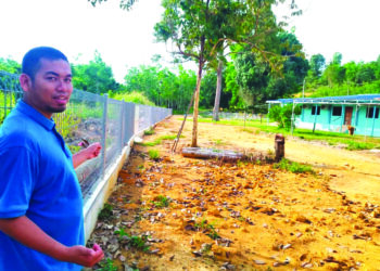 Muhammad Fazrin Mahamad Nazeri menunjukkan tambahan keluasan kawasan masjid selepas pembinaan pagar baharu Masjid An-Nuhiah Kampung Ribu di Kuala Kangsar. - UTUSAN