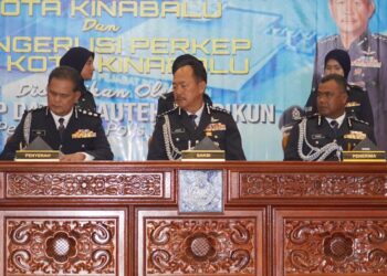 KASIM Muda (kanan) menandatangani dokumen serah terima tugas bersama Mohd. Zaidi Abdullah (kiri) sambil disaksikan oleh Pesuruhjaya Polis Sabah, Datuk Jauteh Dikun (tengah) di Kota Kinabalu, Sabah, hari ini.