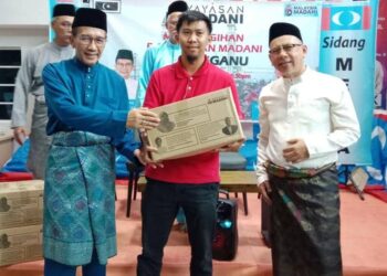 AZAN Ismail (kiri) menyampaikan agihan Bakul Ihsan Madani di Bangunan Keadilan Bukit Besar, Kuala Terengganu, hari ini. - UTUSAN/TENGKU DANISH BAHRI TENGKU YUSOFF