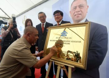 SAARANI Mohamad menandatangani plak perasmian bangunan Rehda Perak di Ipoh, hari ini. - UTUSAN
