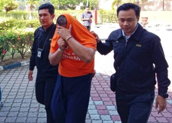 BEKAS penjawat awam (tengah) yang disyaki mengemukakan dokumen palsu bagi mendapatkan pekerjaan dibawa di Mahkamah Majistret Kuala Terengganu, hari ini. - UTUSAN/TENGKU DANISH BAHRI TENGKU YUSOFF