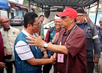 ABIDIN Ismail (dua dari kiri) bersama Dr. Joohari Ariffin ketika bertemu di tapak pasar malam Puteri Gunong, Simpang Ampat, Nibong Tebal, petang tadi.-UTUSAN/IQBAL HAMDAN