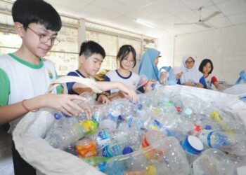 BEBERAPA orang murid mengumpul botol plastik sebelum dijual semula  di SJKC Masai.  – GAMBAR HIASAN