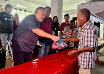 ROZABIL Abd Rahman (tiga dari kiri) menyerahkan daging tempatan yang dijual pada harga serendah RM18 sekilogram bersempena program Jualan Rahmah UMNO Arau (Juara) di pekarangan pejabat UMNO Bahagian Arau, Perlis semalam.-UTUSAN/ASYRAF MUHAMMAD