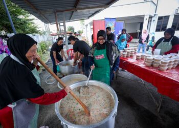 AHLI Pergerakan Wanita Pekebun Kecil Daerah Rembau membantu memasak bubur lambuk pada Program Kongsi Berkat Bubur Lambuk 2025 di Pejabat JHEAINS Cawangan Rembau, Negeri Sembilan kelmarin. – UTUSAN/MUHAMAD IQBAL ROSLI