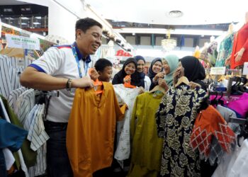 IMRAN Salleh (kiri) bersama-sama kakitangannya membantu memilih baju raya untuk anak-anak Rumah Perlindungan Fitrah Qaseh sempena Majlis Sinar Ramadan di Angsana Johor Bahru Mall, Johor Bahru.-UTUSAN/RAJA JAAFAR ALI