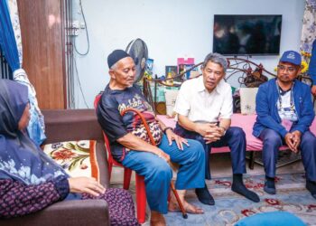 MOHAMAD Hasan (kiri) menyantuni pengundi bersama calon BN pada PRK Ayer Kuning,  Mohamad Yusri Bakir (kanan) di Tapah, semalam. - UTUSAN/MUHAMAD NAZREEN SYAH MUSTHAFA