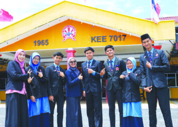 ADAM DANISH Yuslan (tiga dari kiri) bersama rakan-rakan dan guru menunjukkan lencana Jalur Gemilang ketika sesi persekolahan di Sekolah Menengah Kebangsaan Datuk Syed Ahmad di Kuala Nerang, Padang Terap, Kedah. – UTUSAN/SHAHIR NOORDIN