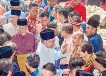Anwar Ibrahim diiringi Abang Johari bersalaman dengan orang ramai pada sambutan Aidilfitri Madani di Stadium Perpaduan, Kuching semalam.