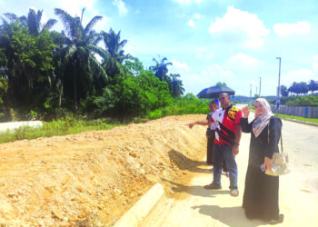 MOHAMAD Rizuan dan penduduk menunjukkan kawasan ban pecah yang menyebabkan banjir di Taman Saujana Aman, Kuala Selangor. – UTUSAN/ISKANDAR SHAH MOHAMED