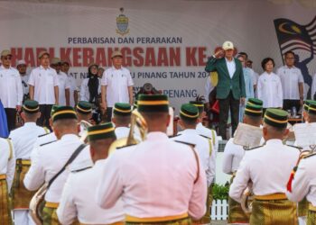 RAMLI Ngah Talib (atas, empat dari kanan) memberikan tabik hormat pada kontinjen yang menyertai acara perbarisan sempena sambutan Hari Kebangsaan peringkat negeri di pekarangan Stadium Batu Kawan, Pulau Pinang hari ini.-UTUSAN/DANIAL SAAD