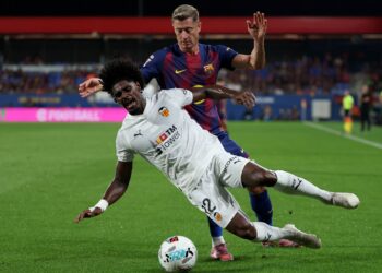 PENYERANG Barcelona, Robert Lewandowski cuba merampas bola daripada pemain Valencia, Thierry Correia pada aksi La Liga di Stadium Johan Cruyff, hari ini.-AFP