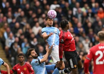 Pemain pertahanan Manchester City, Ruben Dias (tengah) bersaing dengan bek Manchester United, Patrick Dorgu dalam saingan Liga Perdana Inggeris di Stadium Etihad, Manchester, semalam. - AFP