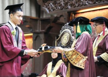 RAJA ZARITH Sofiah menyampaikan Anugerah Diraja kepada Muhammad Najmi Shah Muhamed Azam Shah sempena Majlis Konvensyen ke-69 UTM di Dewan Sultan Iskandar, UTM, Skudai, Johor Bahru, semalam. - UTUSAN/RAJA JAAFAR ALI