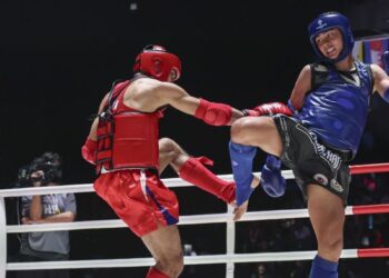 Muhammad Mikail Ghazali Zulfikar (kanan) menang pingat emas dalam acara muay thai kategori 57 kilogram menewaskan lawan tuan rumah, Sirilun Suphakon di Sukan SEA 2025, Bangkok, kelmarin. - UTUSAN/FARIZ RUSADIO