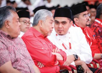 AHMAD Zahid Hamidi mendengar sesuatu daripada Dr. Muhamad Akmal Saleh semasa menghadiri sesi perbahasan Perhimpunan Agung Pergerakan Pemuda UMNO di Pusat Dagangan Dunia, Kuala Lumpur, semalam. – UTUSAN/MUHAMAD IQBAL ROSLI