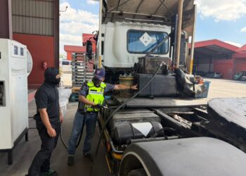 ANGGOTA KPDN melakukan pemeriksaan ke atas sebuah motor lori menerusi serbuan di sebuah premis sekitar Kawasan Perindustrian Padang Besar, Perlis, semalam. -UTUSAN
