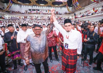 AB. Rauf Yusoh mengangkat tangan Muhamad Akmal Saleh selepas pengumuman perletakan jawatan sebagai Exco Negeri Melaka ketika Ucapan Dasar Ketua Pergerakan Pemuda UMNO sempena Perhimpunan Agung UMNO 2025 di Pusat Dagangan Dunia.