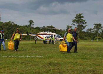 PETUGAS SPR membawa peti undi pertama yang tiba PPRU Dewan Sri Lamag, Kinabatangan, Sabah. - JABATAN PENYIARAN