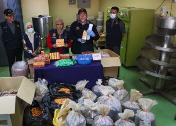 DR. Fazilah Shaikh Allaudin (tengah) dan Mohd Zawawi Abdullah (dua dari kanan) menunjukkan sebahagian daripada ubat tidak berdaftar yang dirampas dalam serbuan di sekitar kawasan Juru dan Simpang Ampat di Bukit Mertajam, Pulau Pinang hari ini.-UTUSAN/DANIAL SAAD