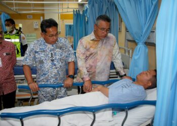 ADLY Zahari melawat Mohamad Zulfika Mohiddi diiringi Shamsuddin Ludin (kiri) yang mendapatkan rawatan di Unit Kecemasan, Hospital Melaka hari ini. - UTUSAN/AMRAN MULUP