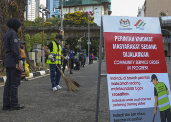 SEBAHAGIAN pelaku kesalahan membuang sampah kecil di tempat awam menjalani hukuman Perintah Khidmat Masyarakat  di hadapan Bangunan Sultan Abdul Samad, Kuala Lumpur, semalam.-UTUSAN/AMIR KHALID