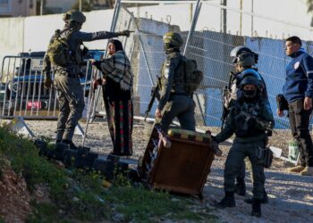 SEORANG askar Israel bercakap dengan wanita Palestin di Ramallah, Tebing Barat semalam. - Foto AFP