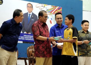 MOHAMED Khaled Nordin menyampaikan sumbangan pada Program Back To School Parlimen Pasir Gudang di Dewan Muafakat Bandar Seri Alam, di sini hari ini. - UTUSAN/RAJA JAAFAR ALI