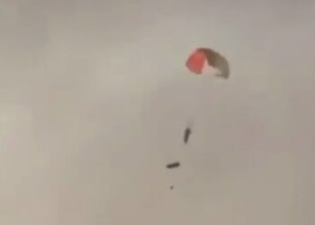 SEORANG  juruterbang menggunakan payung terjun berhampiran al-Jahra di Kuwait selepas tiga jet AS silapt ditembak di Kuwait. - AFP