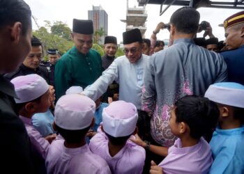 ANWAR Ibrahim menyantuni kanak-kanak ketika hadir menunaikan solat Jumaat di Surau Bomba Cyberjaya. - UTUSAN/FAISOL MUSTAFA