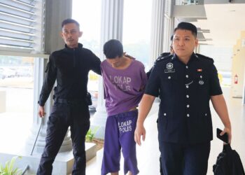 TERTUDUH dibawa polis menghadiri prosiding  di Mahkamah Sesyen Pasir Mas, Kelantan, semalam. – UTUSAN/KAMARUL BISMI KAMARUZAMAN