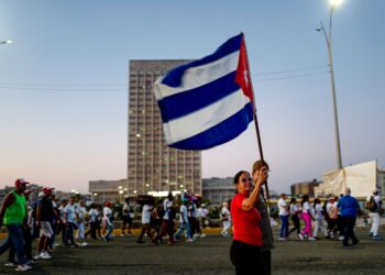 SEORANG wanita memegang bendera kebangsaan Cuba di sepanjang kawasan pantai Havana sempena Hari Pekerja Antarabangsa di hadapan Kedutaan AS di Havana pada 1 Mei lalu.- AFP