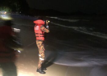 ANGGOTA bomba melakukan pencarian dengan memantau kawasan pesisir di Pantai Tengah, Langkawi.